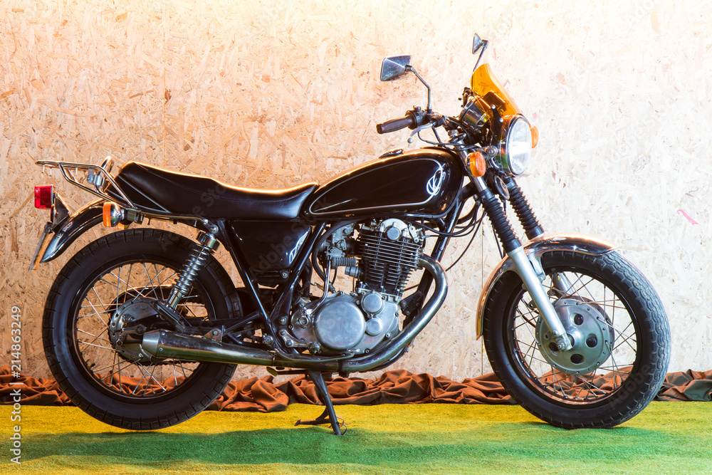 Classic black motorcycle on a green carpet.