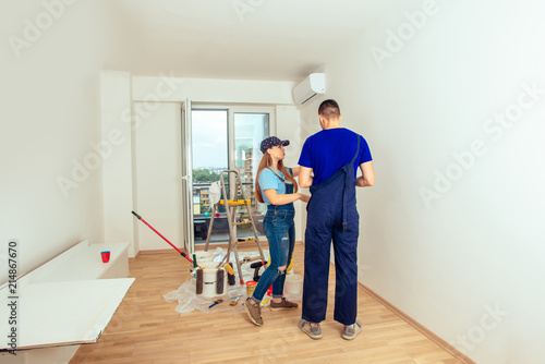 Young couple prepare to paint wall at home. Home renovation and improvement concept.