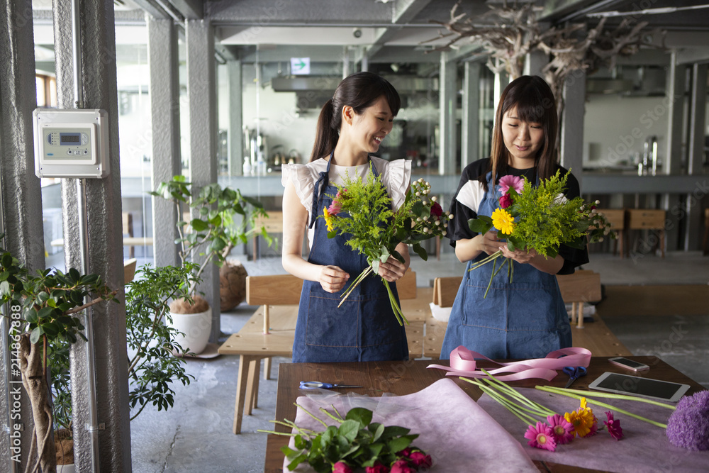 花屋の店員二人がお客様の為に花束を準備している