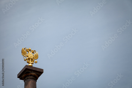 Coat of arms of Russia, golden two-headed eagle against the blue sky. Gold Russian heraldic symbol background with copy space