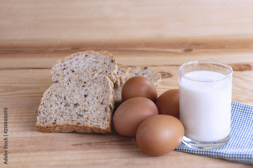 Prepare breakfast with eggs, milk, bread on a wooden table. Prepare breakfast with eggs, milk, bread on a wooden table.