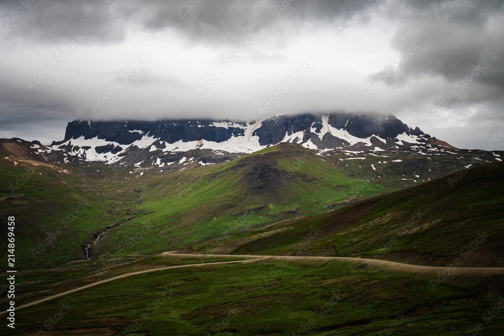 Scenic view of green mountain with dramatic sky near Borgarfjorour Eystri in East Iceland.