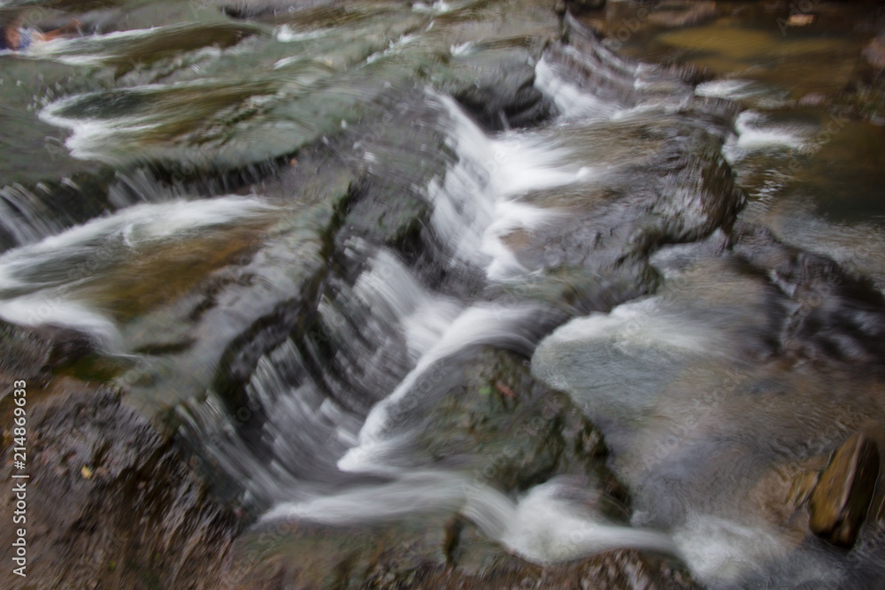 Waterfall with a pathway in green garden