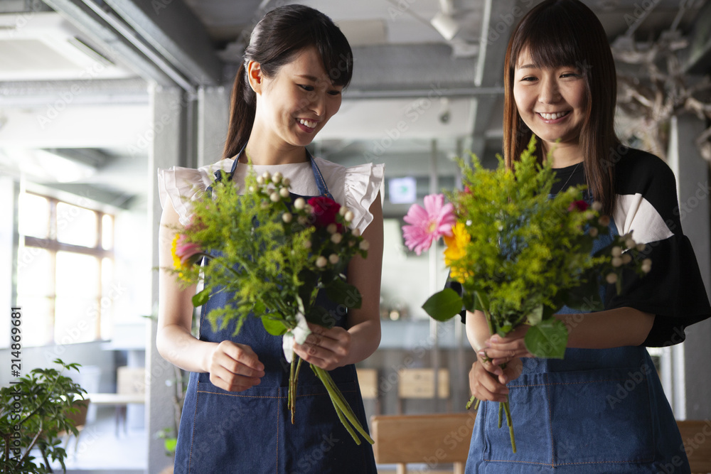 フラワーアレンジメント教室で花を手に取り微笑む女性二人