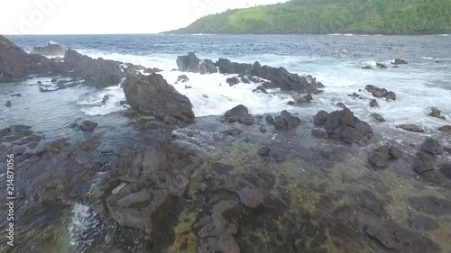 A quick aerial shot of a famous landmark in St.Vincent and the Grenadines - Rawracou Beach. The rocks form a natural barrier that shelters the beach from the rough Atlantic waves hitting the shore. photo