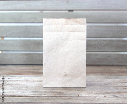 Brown paper bag on old wood table.