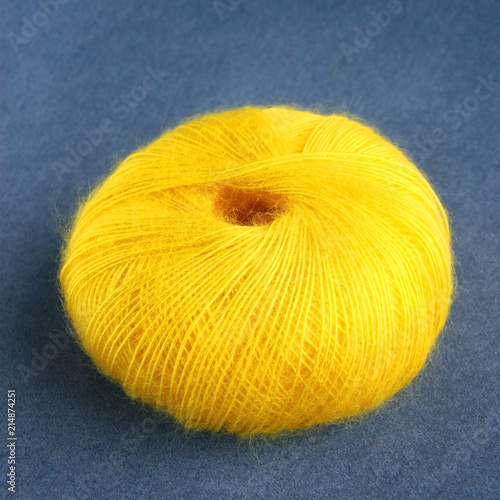 Yellow yarn ball of mohair (angora) wool for knitting on the velvet background.