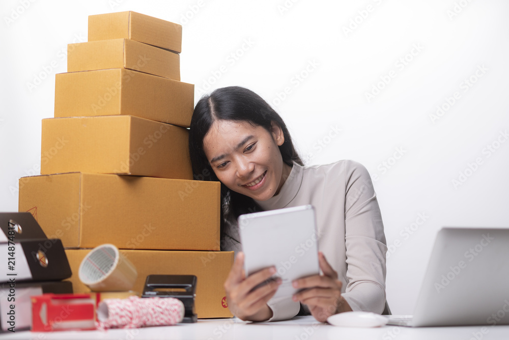 Young Women happy after new order from customer, business owner working at home office packaging on background. online shopping SME entrepreneur or freelance working concept. Young Women happy after new order from customer, business owner working at home office packaging on background. online shopping SME entrepreneur or freelance working concept.