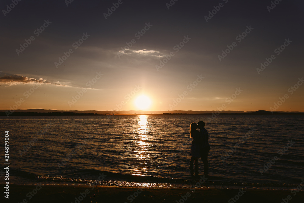 Silhouette couples in the sea at sunset