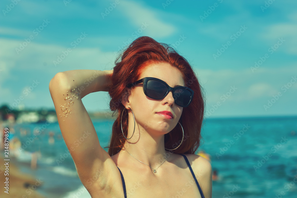 portrait of a young red-haired woman on the sea .Young girl lying on the beach portrait of a young red-haired woman on the sea .Young girl lying on the beach