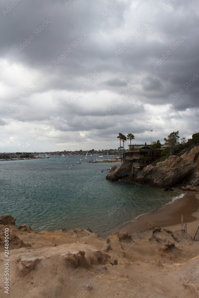 Gathering storm clouds over the channel. View of the coastal access to the harbor from a rocky cliff. Southern California coastline vacation destinations in the USA