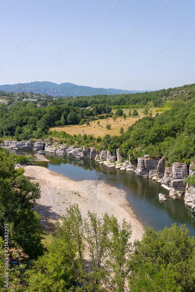 Landscape with the river Ardeche, framed by rock faces and much vegetation at 