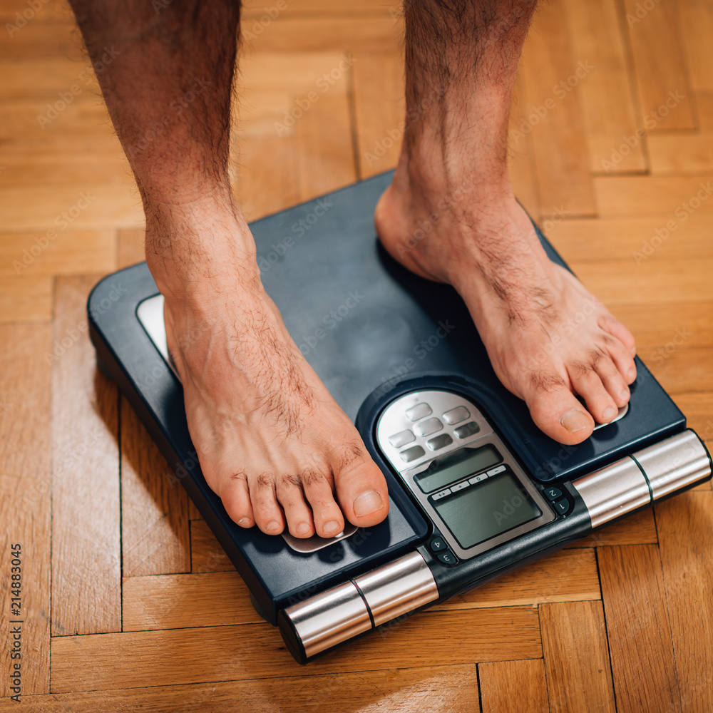 Measuring weight using body scale Stock Photo | Adobe Stock