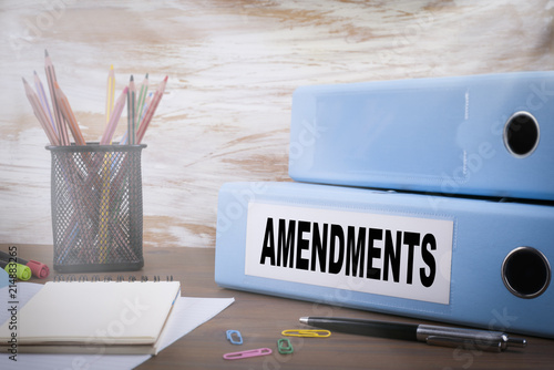 Amendments. Office Binder on Wooden Desk. On the table colored pencils, pen, notebook paper