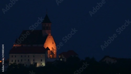 Illuminated Church on hill at dusk, Ptujska Gora, Slovenia, slow zoom pull after 5s photo