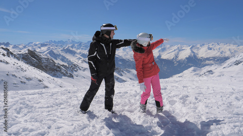 Skiers saw something interesting in the mountain valley and hand show each other