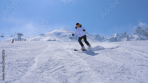 A Woman Skier Carving Go Down The Ski Slope Of The Mountain