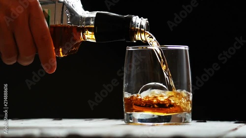 Glass with ice and scotch whiskey on wooden glass