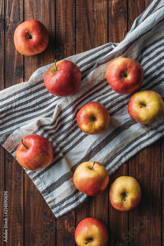 flat lay with arranged ripe apples on linen on wooden surface