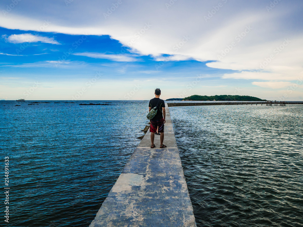 Asian guy stand on Concrete bridges on the ocean with idyllic ocean and beautiful Sky in vacation time,Holiday in the sea,Summer concept Asian guy stand on Concrete bridges on the ocean with idyllic ocean and beautiful Sky in vacation time,Holiday in the sea,Summer concept