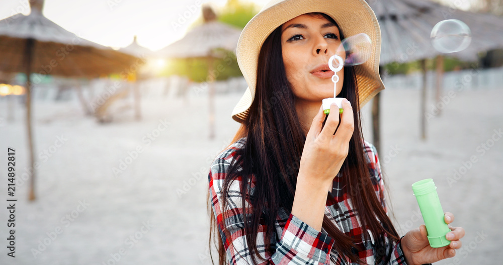 Happy young woman blowing bubbles on the beach Happy young woman blowing bubbles on the beach