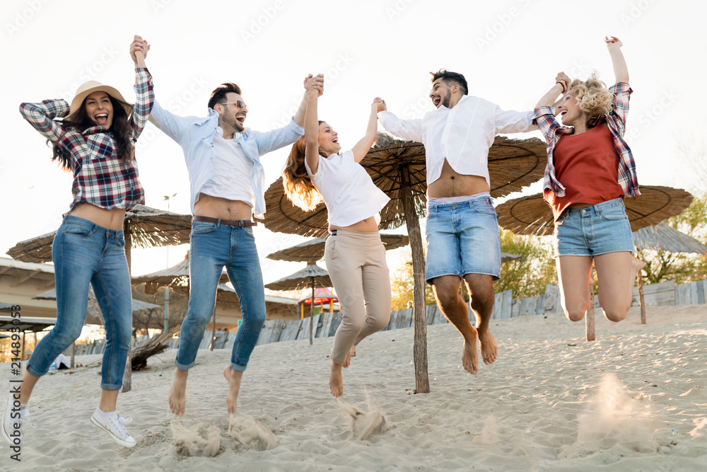 Obraz premium Friends partying and having fun on beach at summer