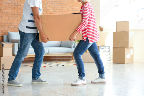 Couple moving cardboard box...