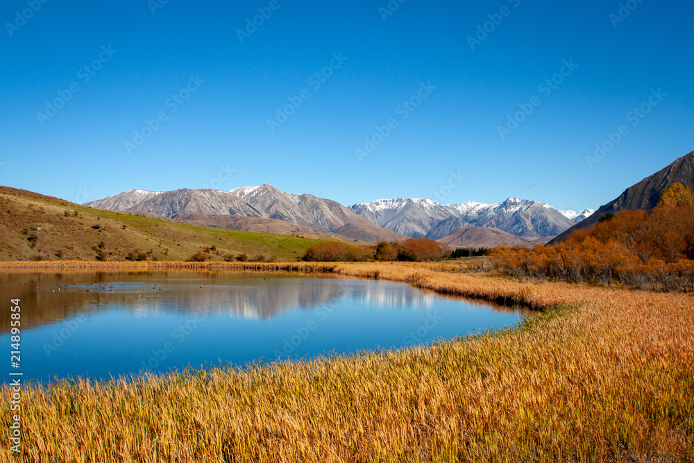 A calm, clear lake in the high country sets a beautiful landscape scene on an autumn day
