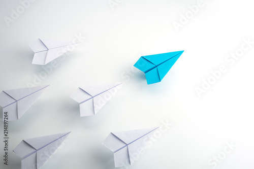 Blue paper plane leader concept, white background.