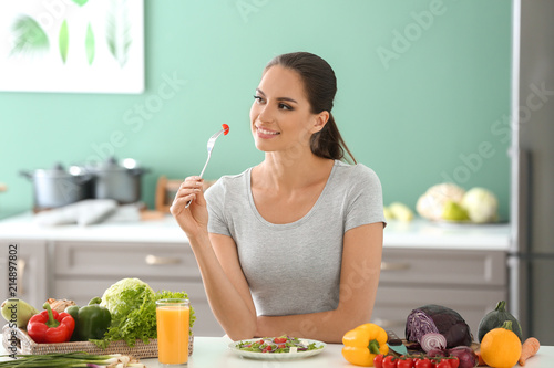 Young woman eating fresh ve...