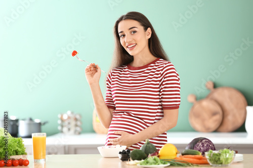 Young pregnant woman eating...