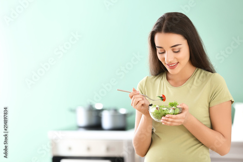 Young pregnant woman eating...