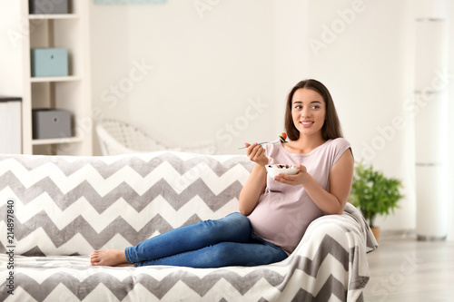 Young pregnant woman eating...
