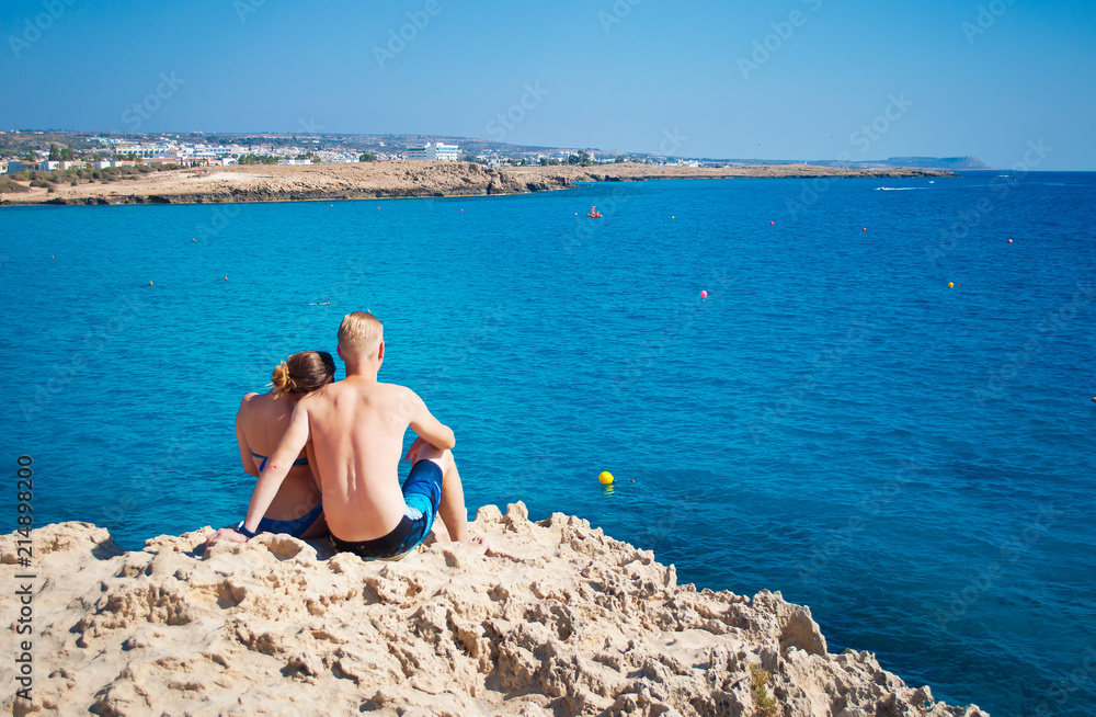 Romantic couple sitting together on a rock