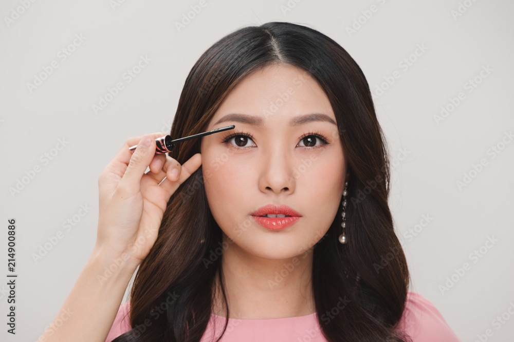 Beauty Make-up. Portrait Of Beautiful Young Woman With Fake Eyelashes Applying Black Mascara On Lashes, Holding Brush In Hand Beauty Make-up. Portrait Of Beautiful Young Woman With Fake Eyelashes Applying Black Mascara On Lashes, Holding Brush In Hand