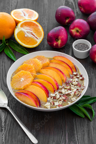 Breakfast smoothie bowl with peaches, oranges, almonds. Flat lay. 