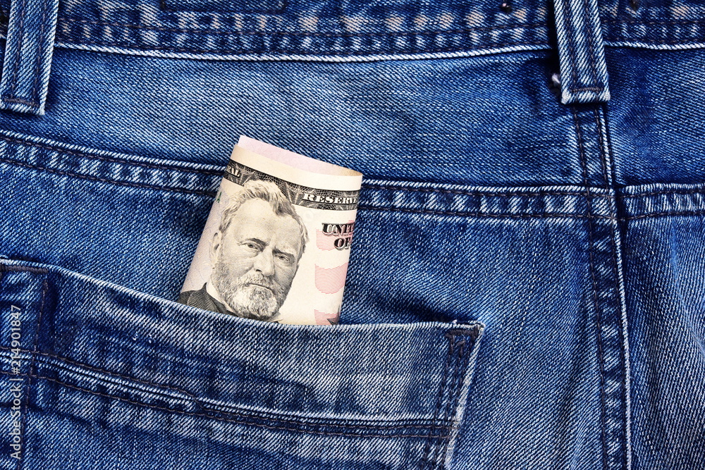 The president Grant on a 50 dollar bill peeps out of his jeans pocket. Concept on the topic of illegal work. The president Grant on a 50 dollar bill peeps out of his jeans pocket. Concept on the topic of illegal work.