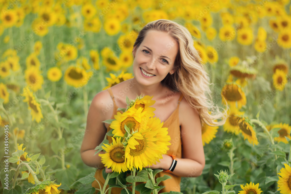 Happy woman with sunflowers. The girl in the fields of a sunflower Happy woman with sunflowers. The girl in the fields of a sunflower