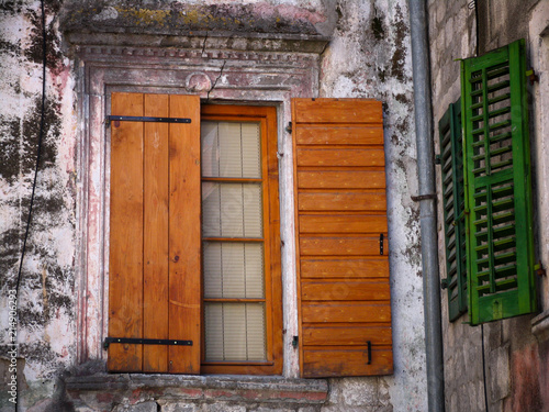 window with brown and green village shutters
