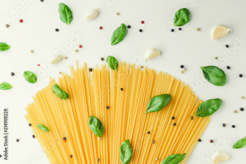 Concept food with pasta, basil, garlic and pepper on a white background. Bouquet of spaghetti and spices
