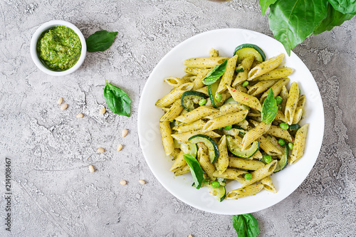 Fotografia Penne pasta with  pesto sauce, zucchini, green peas and basil