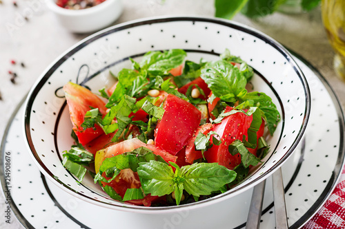 Tomato salad with basil and pine nuts in bowl - healthy vegetarian vegan diet organic food appetizer.