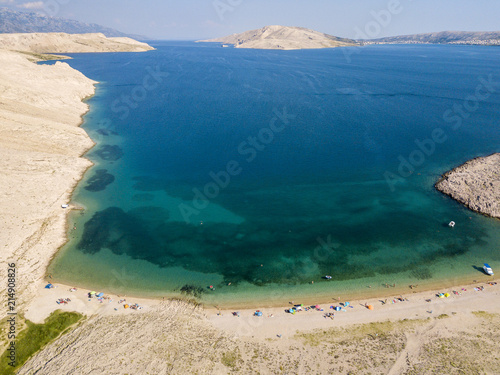 Vista aerea della spiaggia di Rucica sull’isola di Pag, Metajna, Croazia. Fondale marino e spiaggia vista dall’alto, bagnanti, relax e vacanze estive. Promontori e scogliere delle coste croate. photo