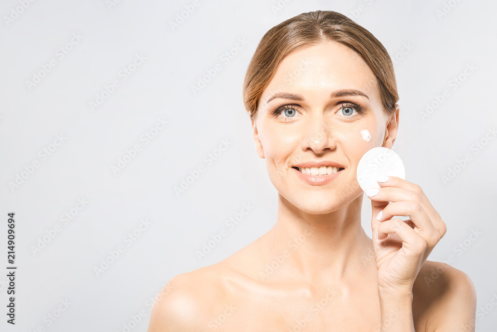Healthy fresh girl removing makeup from her face with cotton pad. Beauty woman cleaning her face with cotton swab pad isolated on isolated white background. Skin care and beauty concept. Healthy fresh girl removing makeup from her face with cotton pad. Beauty woman cleaning her face with cotton swab pad isolated on isolated white background. Skin care and beauty concept.
