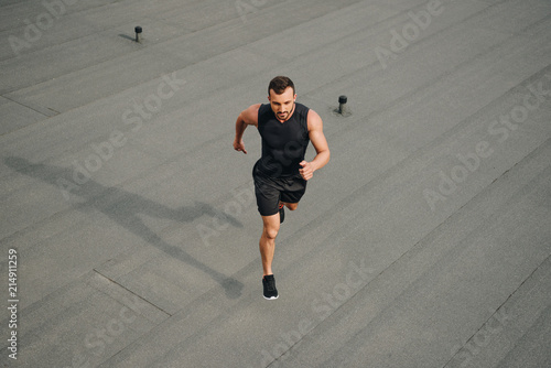 high angle view of handsome sportsman running on roof