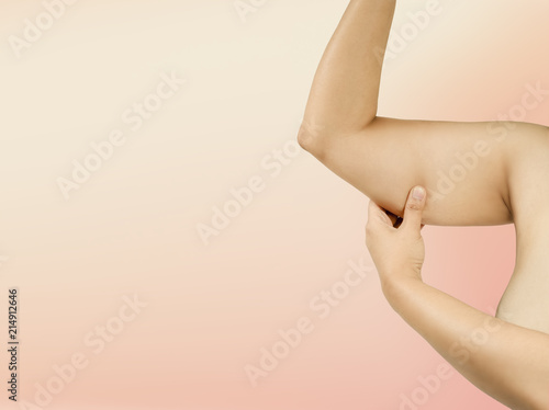  Girl Checking Excess Fat On Upper Arm. Concept of Fitness Lifestyle and Body Positivity for Woman