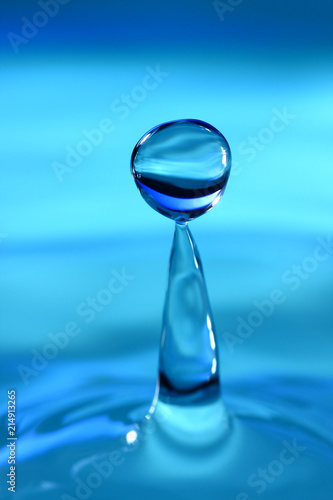 Water drop splashing against a blue background