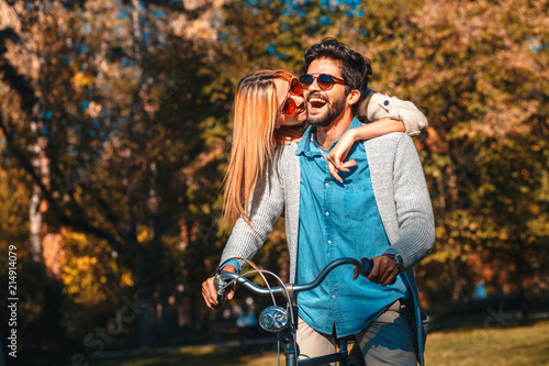 Happy young couple having fun riding a bicycle on sunny day in the park. © Zoran Zeremski