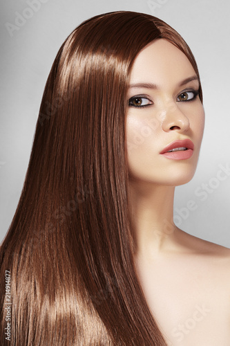 Beautiful yong Woman with Long Straight Brown Hair. Sexy Fashion Model with Smooth Gloss Hairstyle. Keratine Treatment
