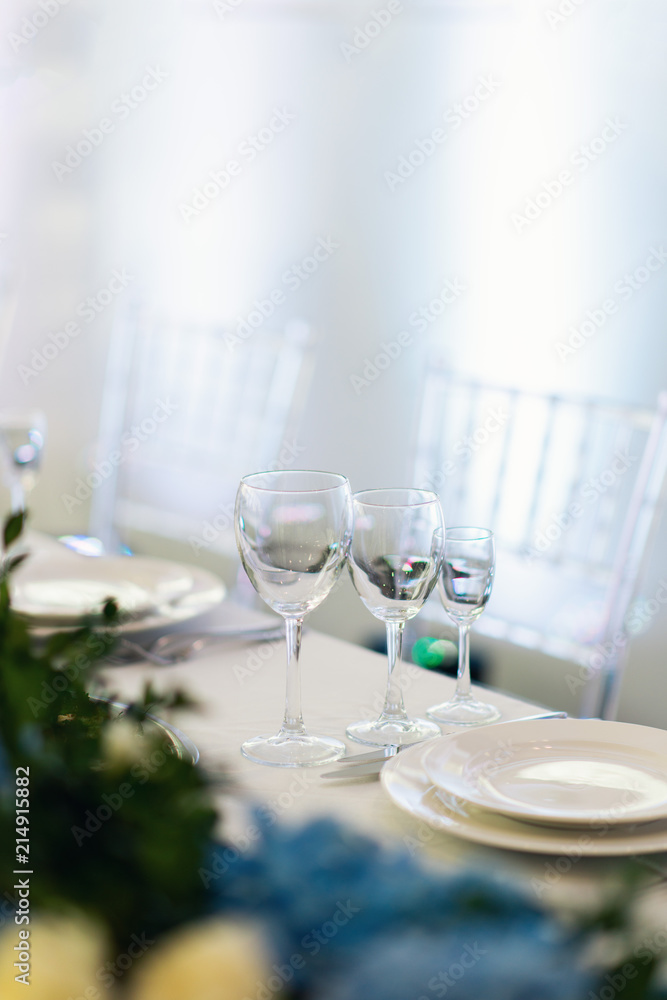 Sparkling glassware stands on long table prepared for wedding Sparkling glassware stands on long table prepared for wedding